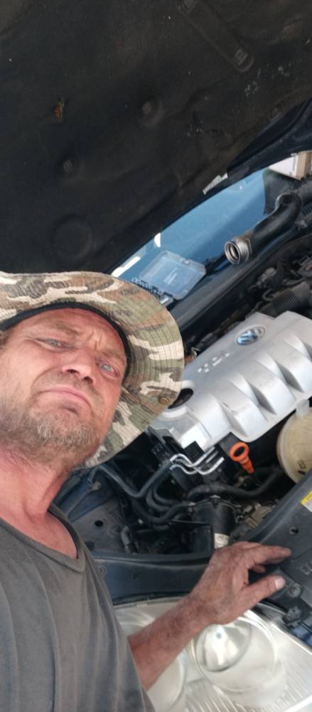 Robert Kious working under the hood of a car