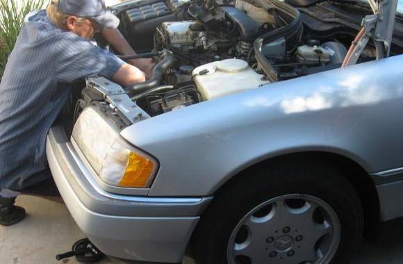 Robert Kious working under the hood of a silver Mercedes-Benz C-Class